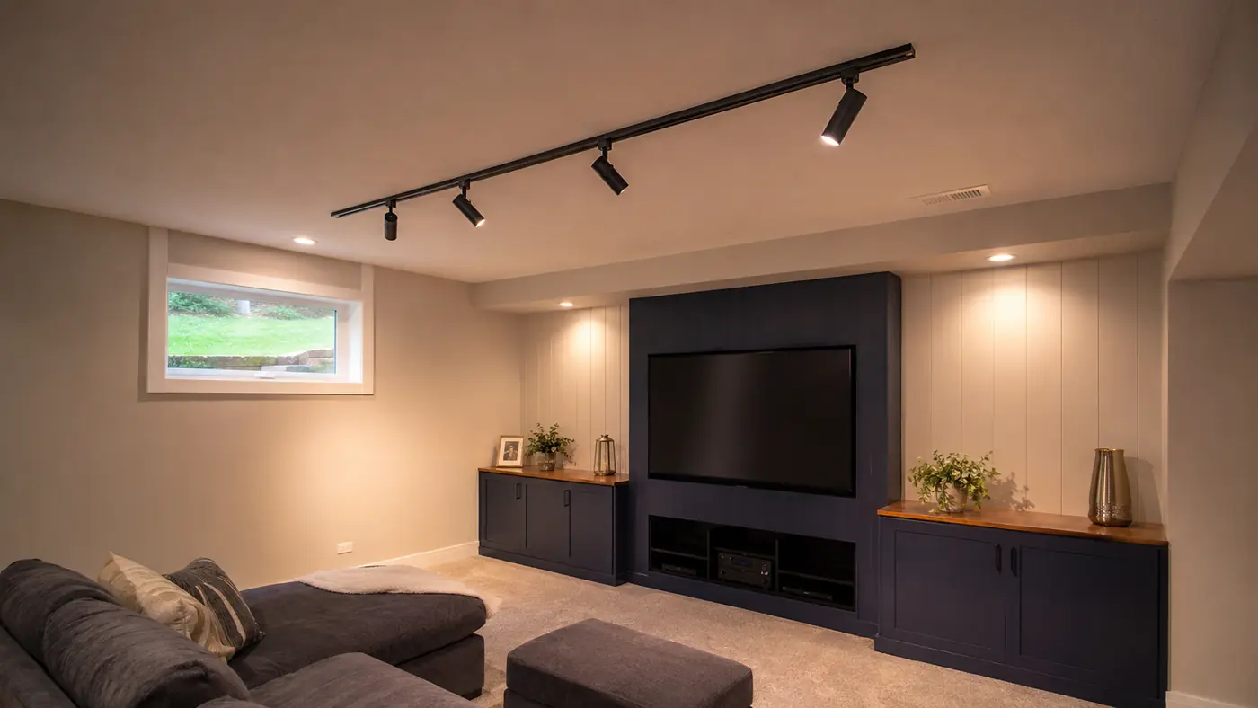 Track lighting installed over a basement media wall in Mason, OH