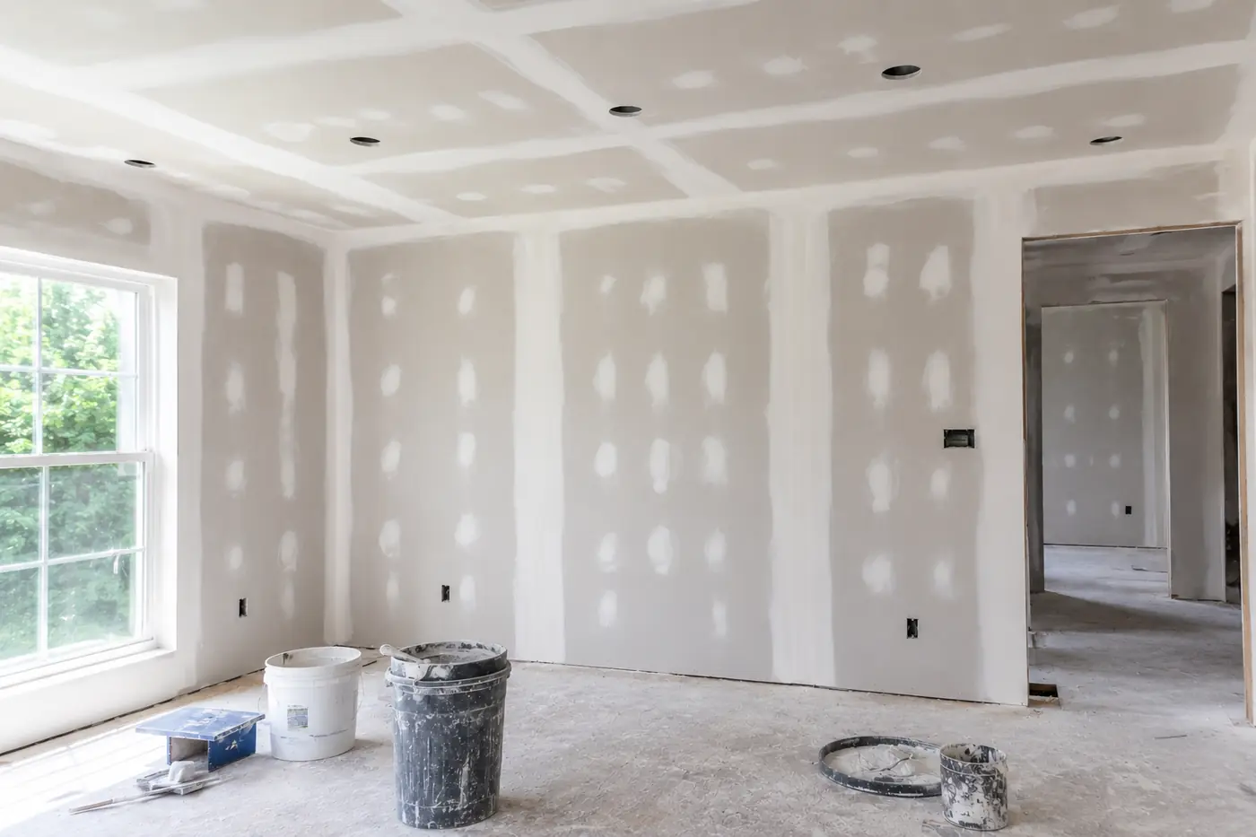Drywall seams mudded and sanded with joint compound buckets on site in Mason, OH