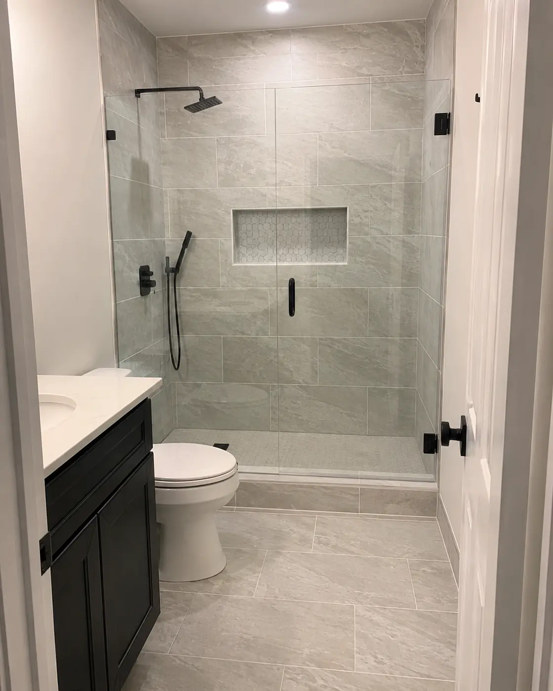 Walk-in shower with gray stone-look wall tile and matte black fixtures in Mason, OH