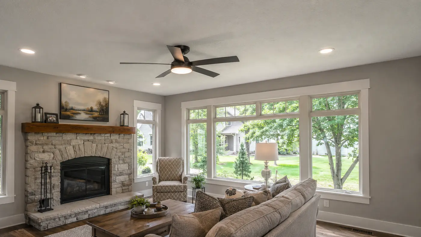 Living room with new ceiling fan and recessed lighting around a stone fireplace in Mason, OH