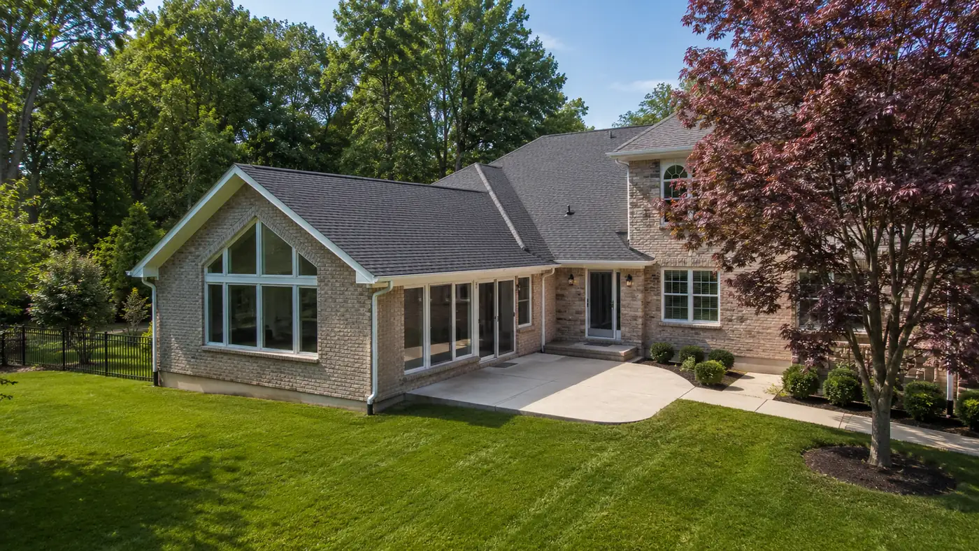 Rear home addition with vaulted gable and patio overlooking the lawn in Mason, OH